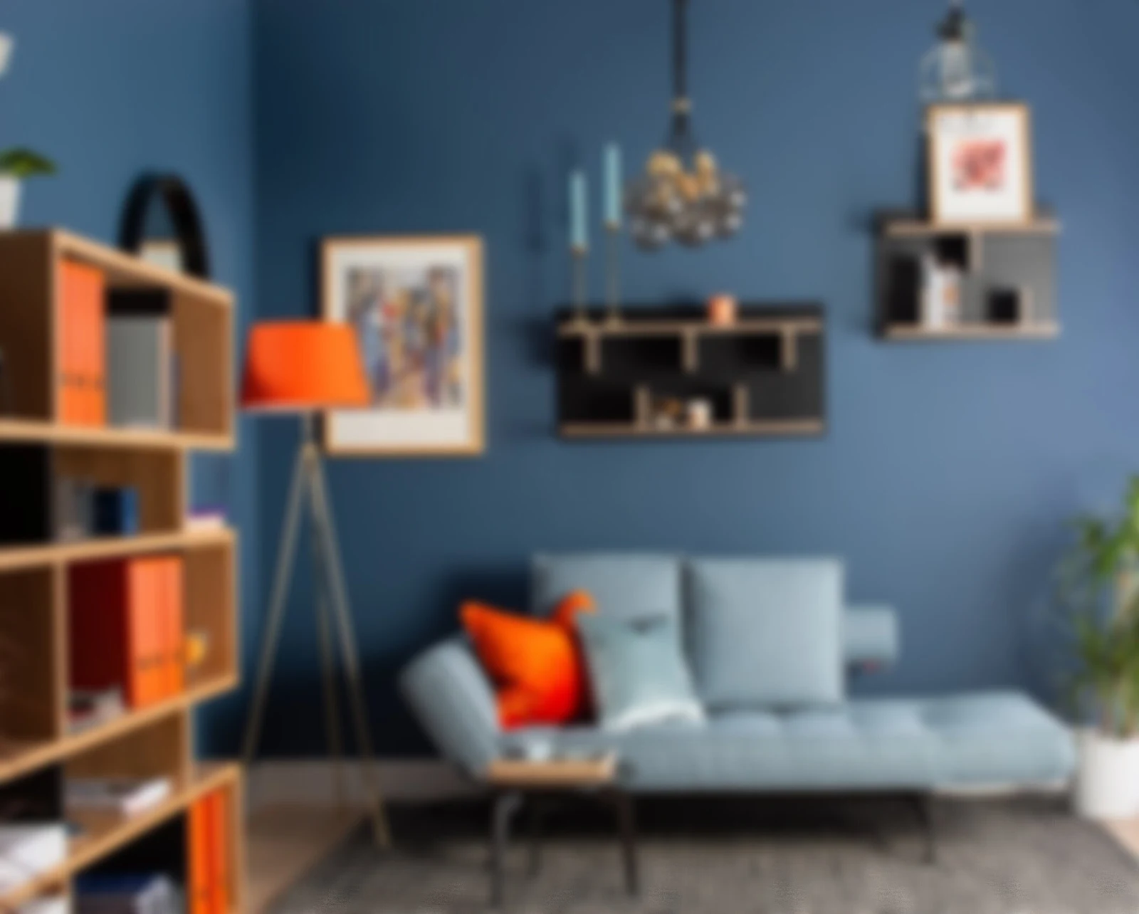 Living room with rich blue painted walls, coordinating sofa and warm wood shelves